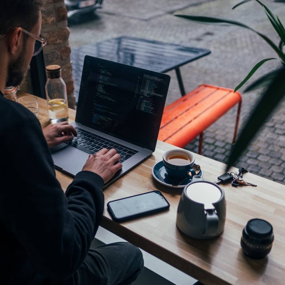 Person working on laptop at a café